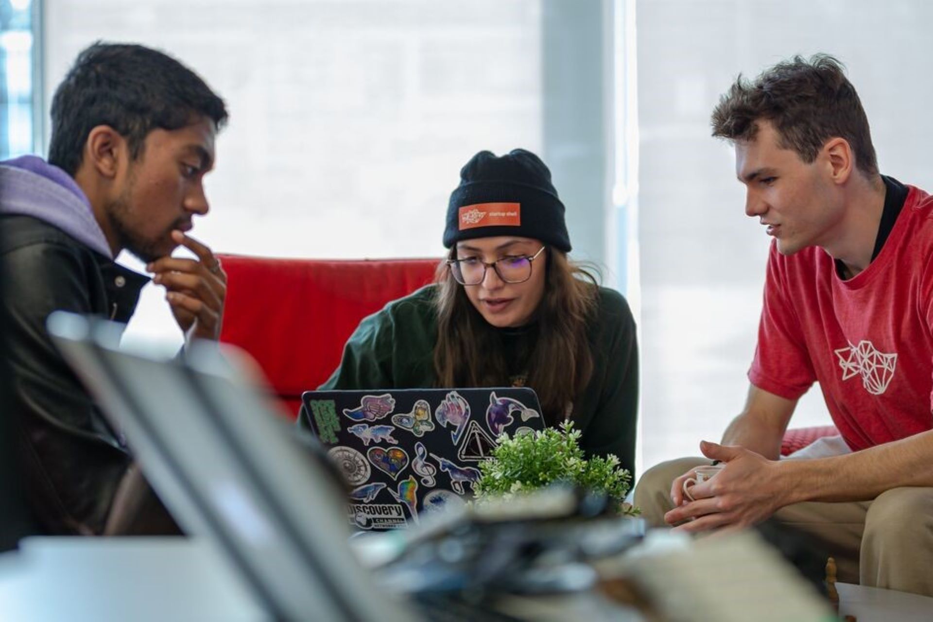 three people looking at a laptop