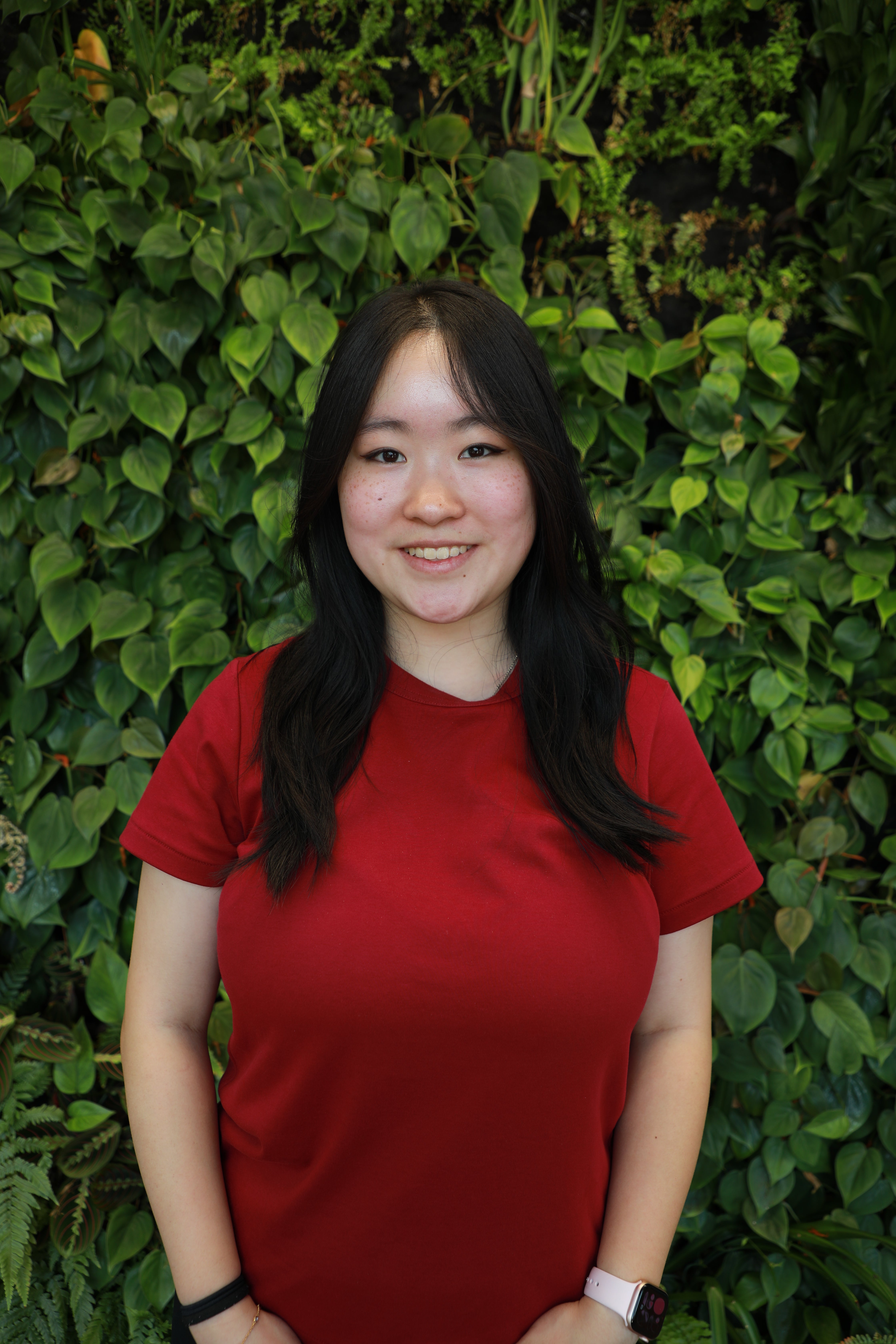 Claire Chen smiling in front of green wall