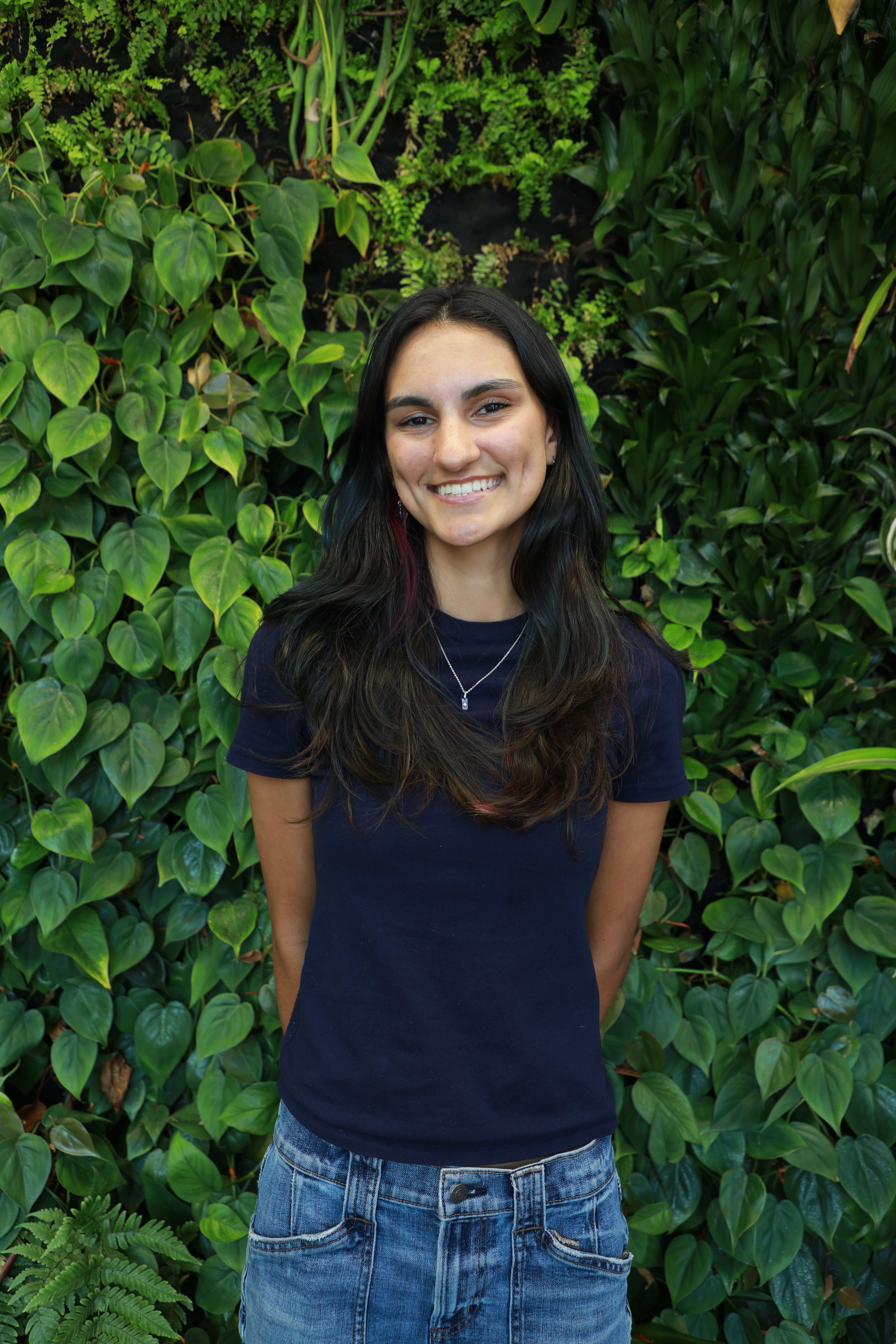 Lauren Keister smiling in front of green wall.