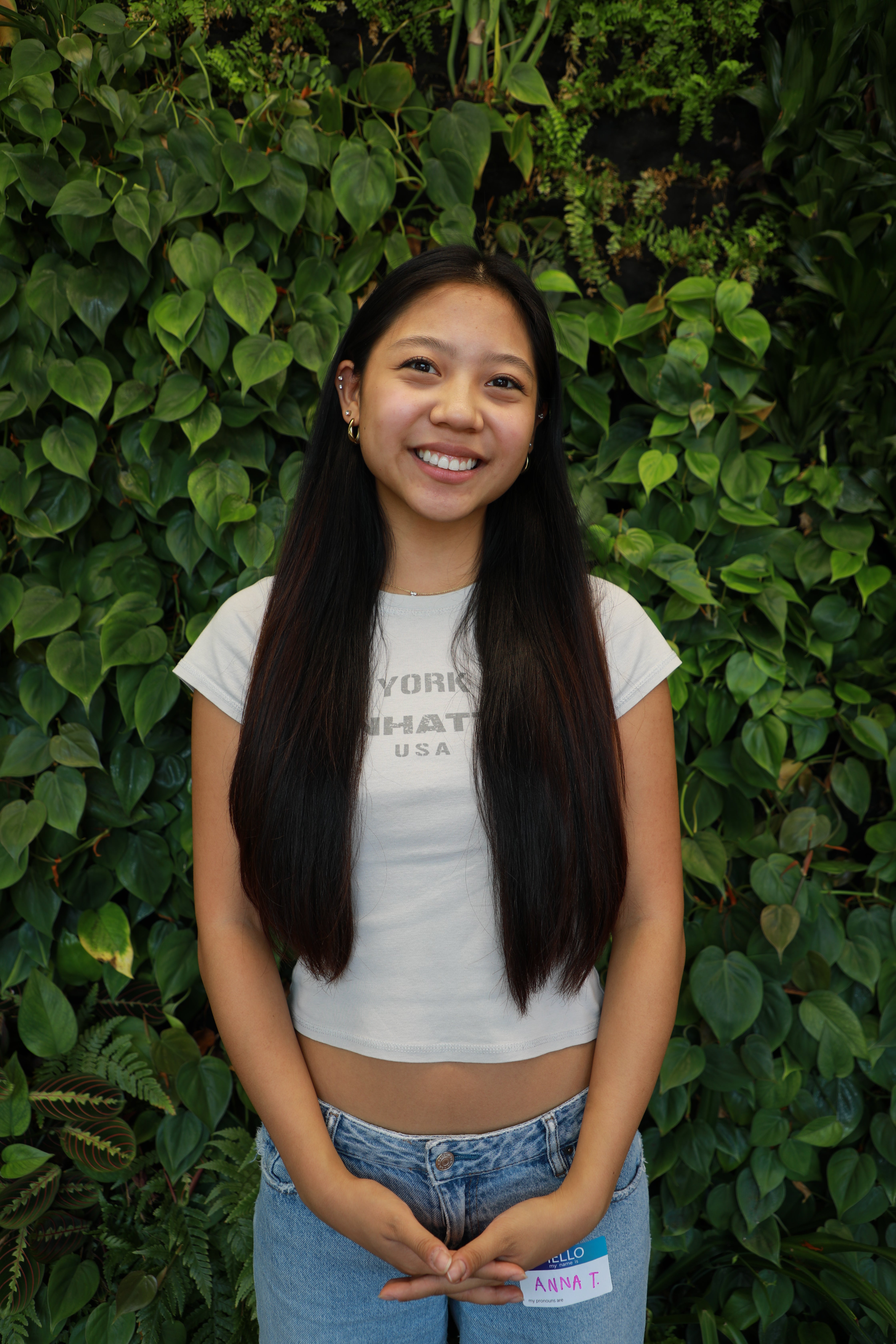 Anna smiling in front of green wall.