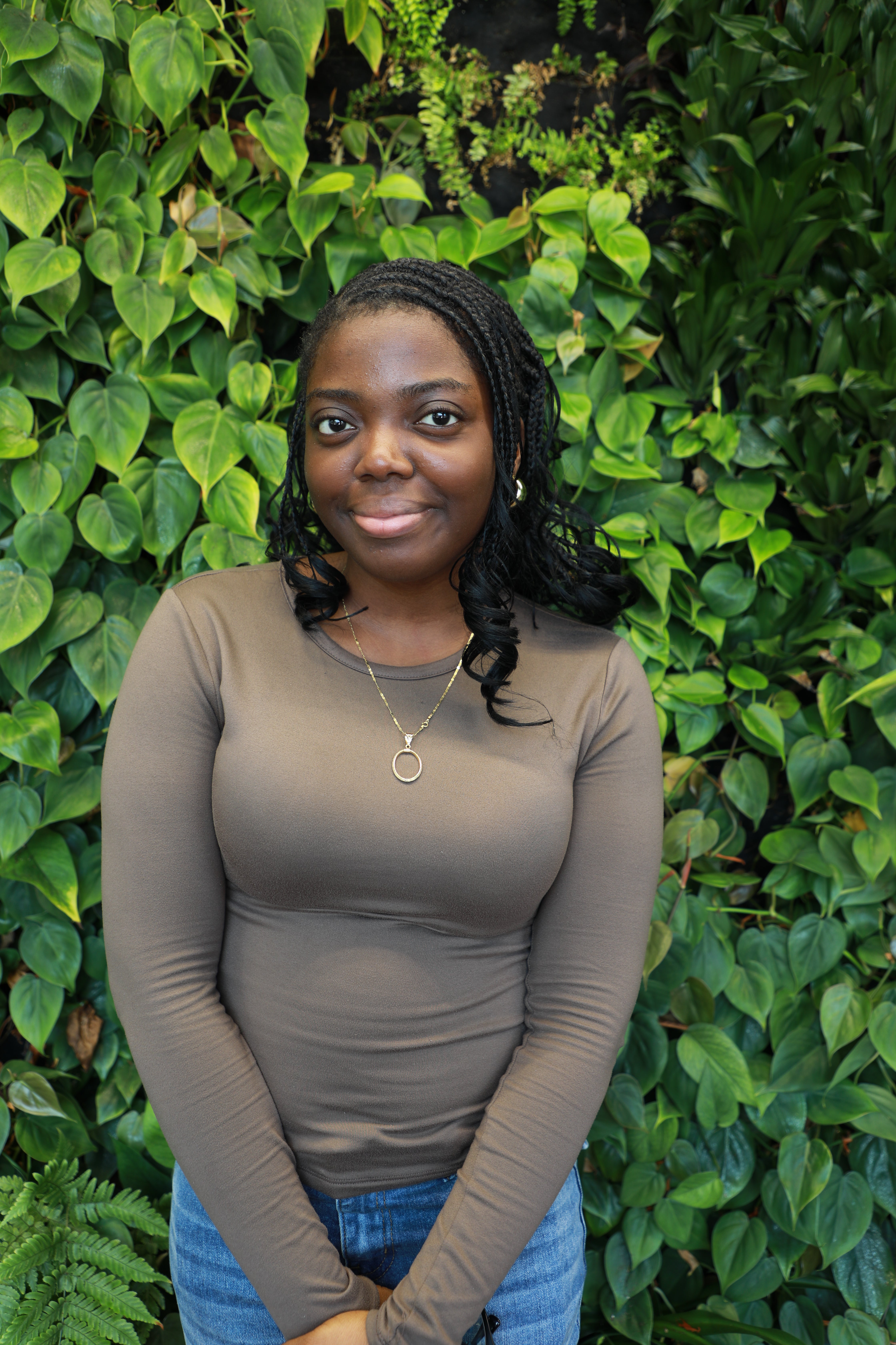 Ife smiling in front of green wall.