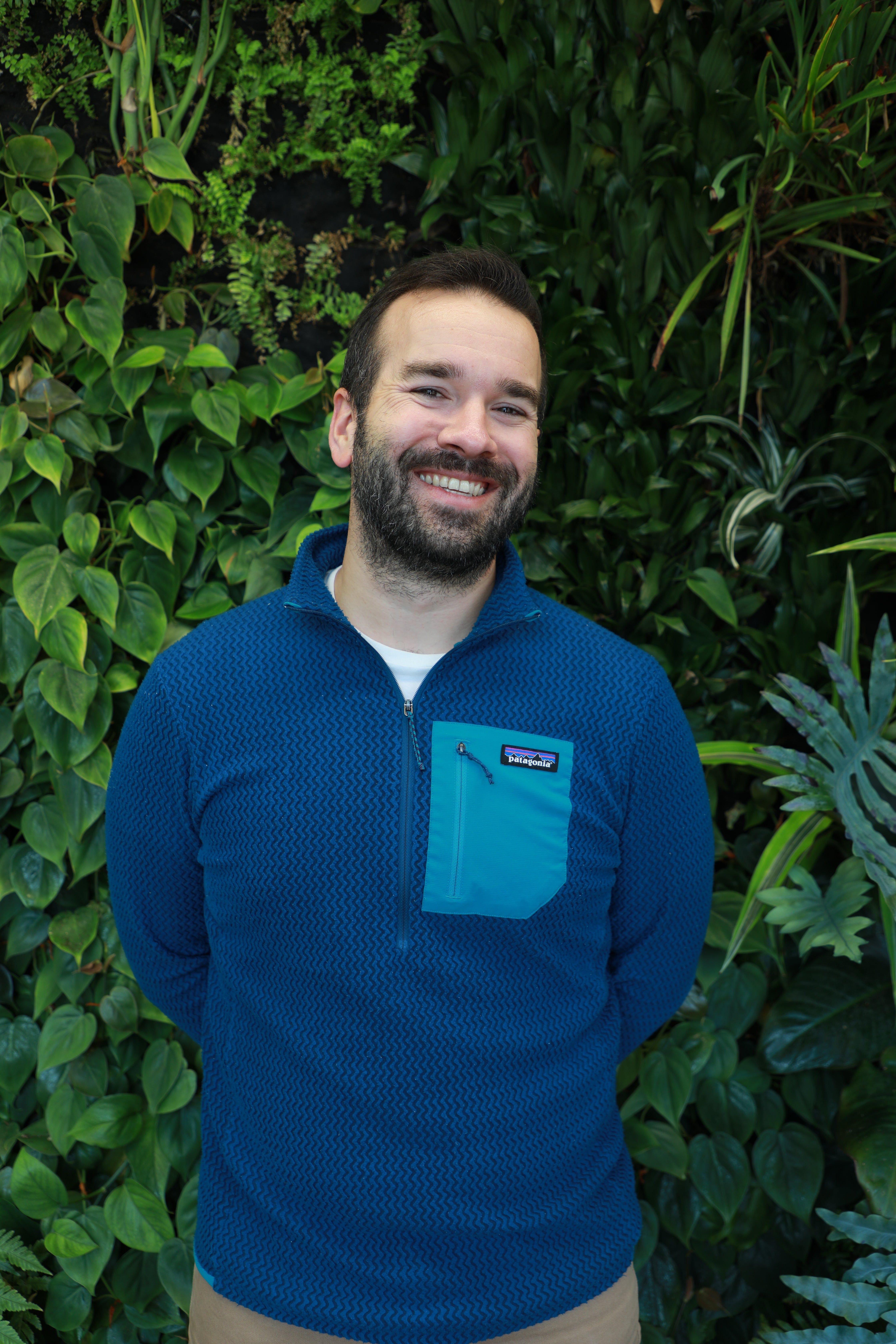 William Post smiling in front of green wall.
