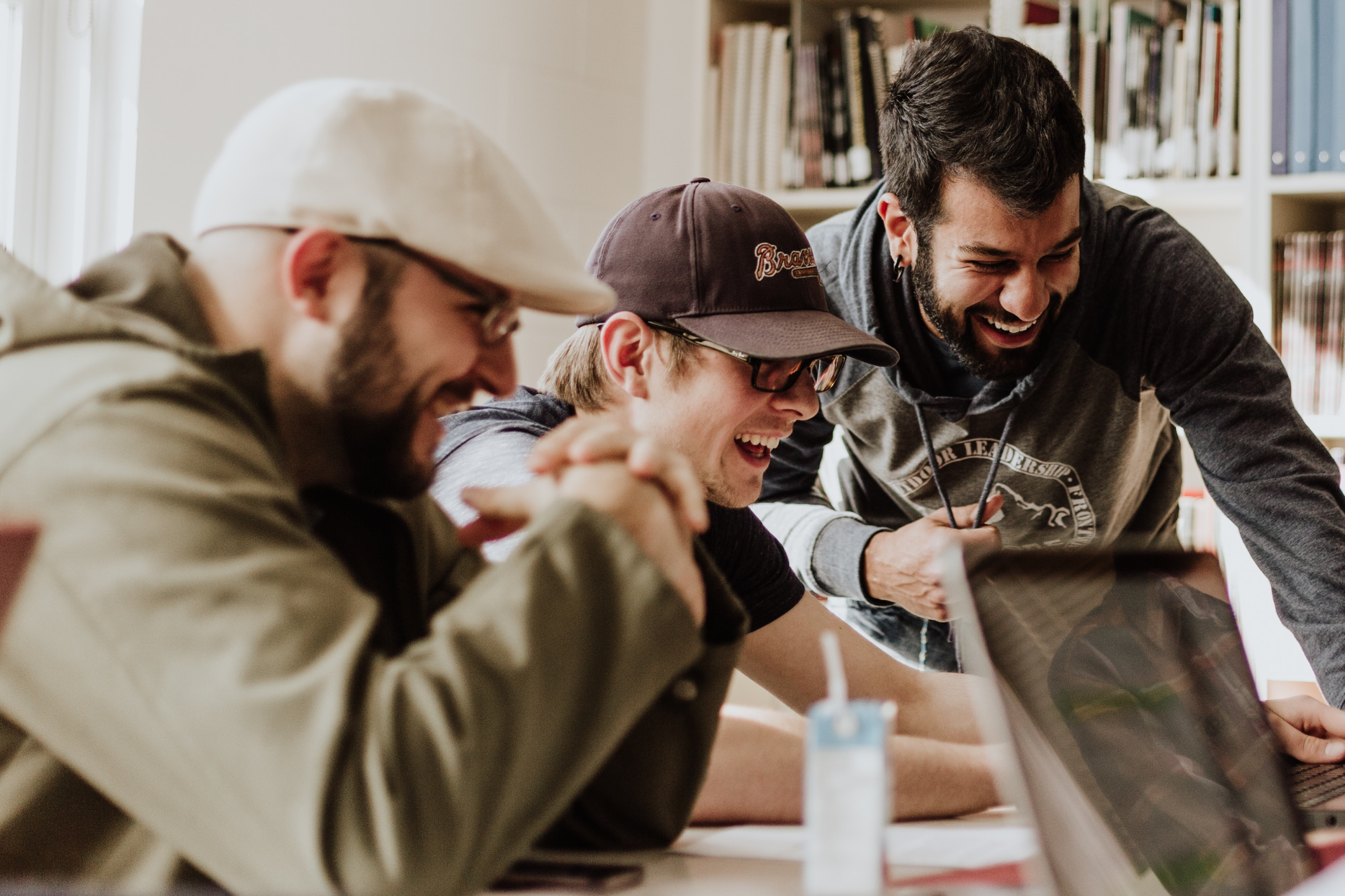 students looking at a laptop and laughing