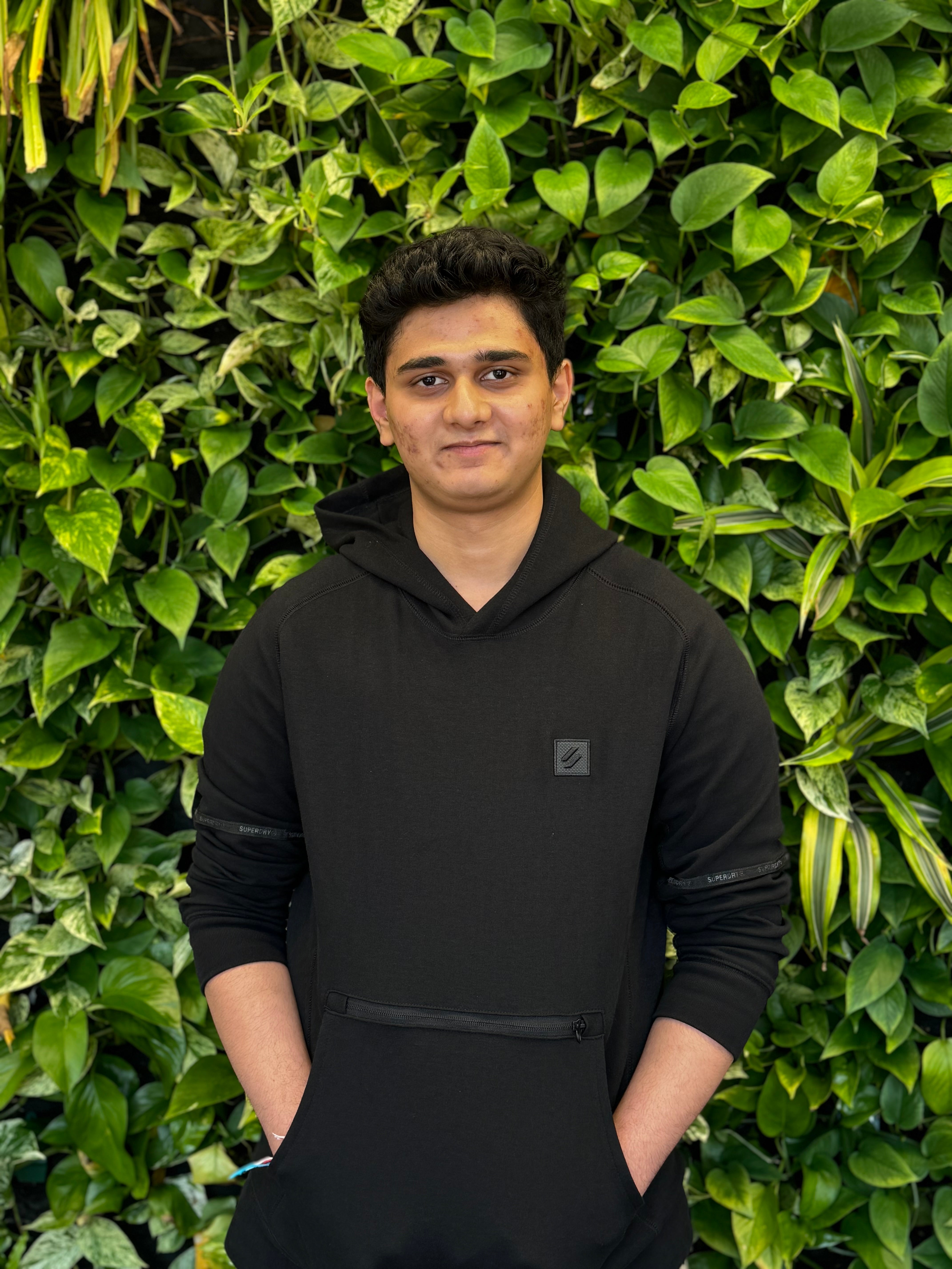 Dylan smiling in front of green wall.