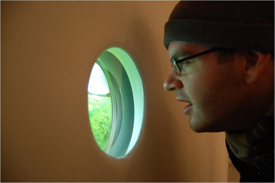 Eldis Sula looks into Patrick Jacobs's Fairy Ring with White Clover (2010) acquired by his committee in 2011. Photo courtesy of Eldis Sula.