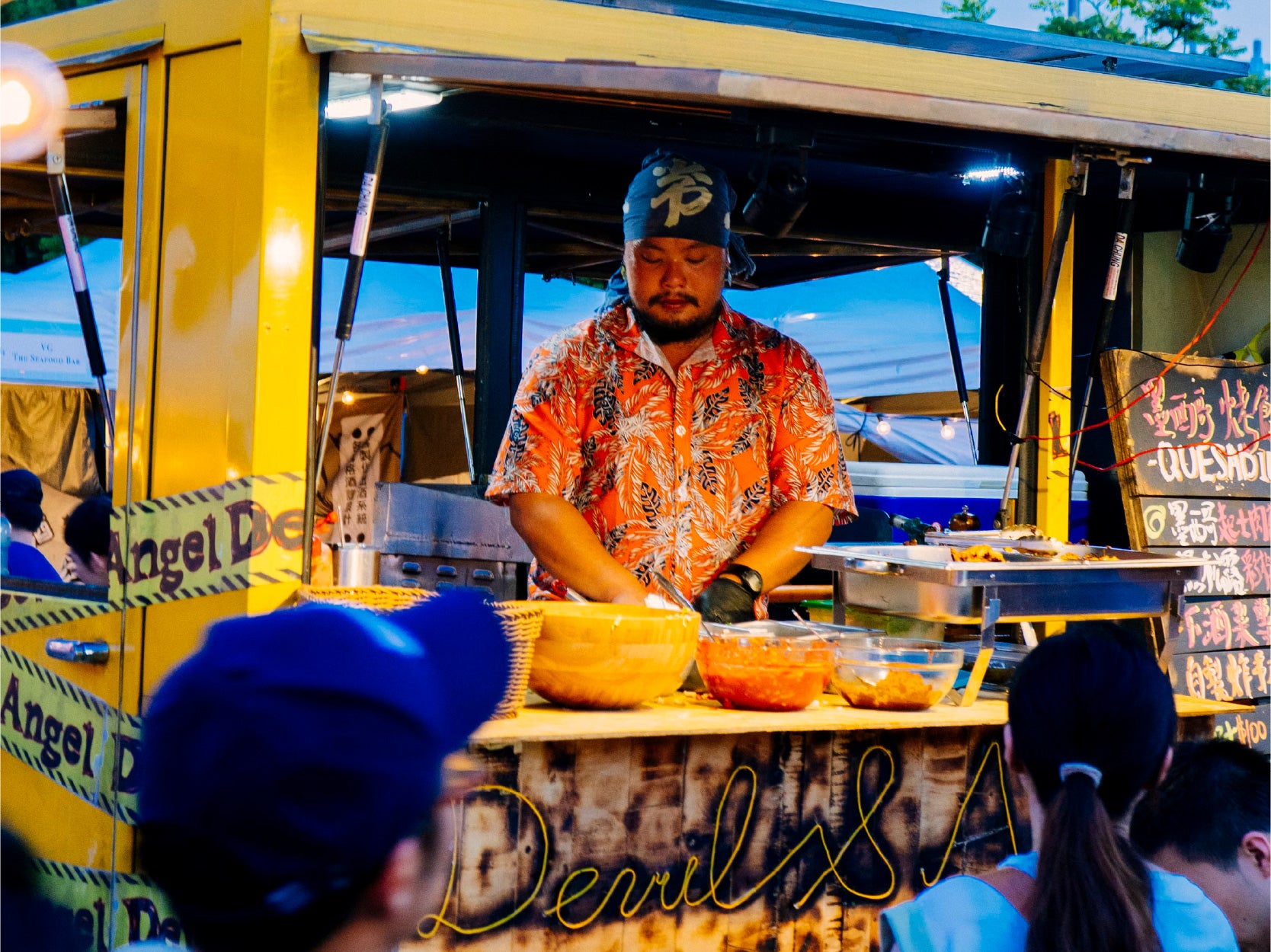 A cook prepares food in a food truck window.