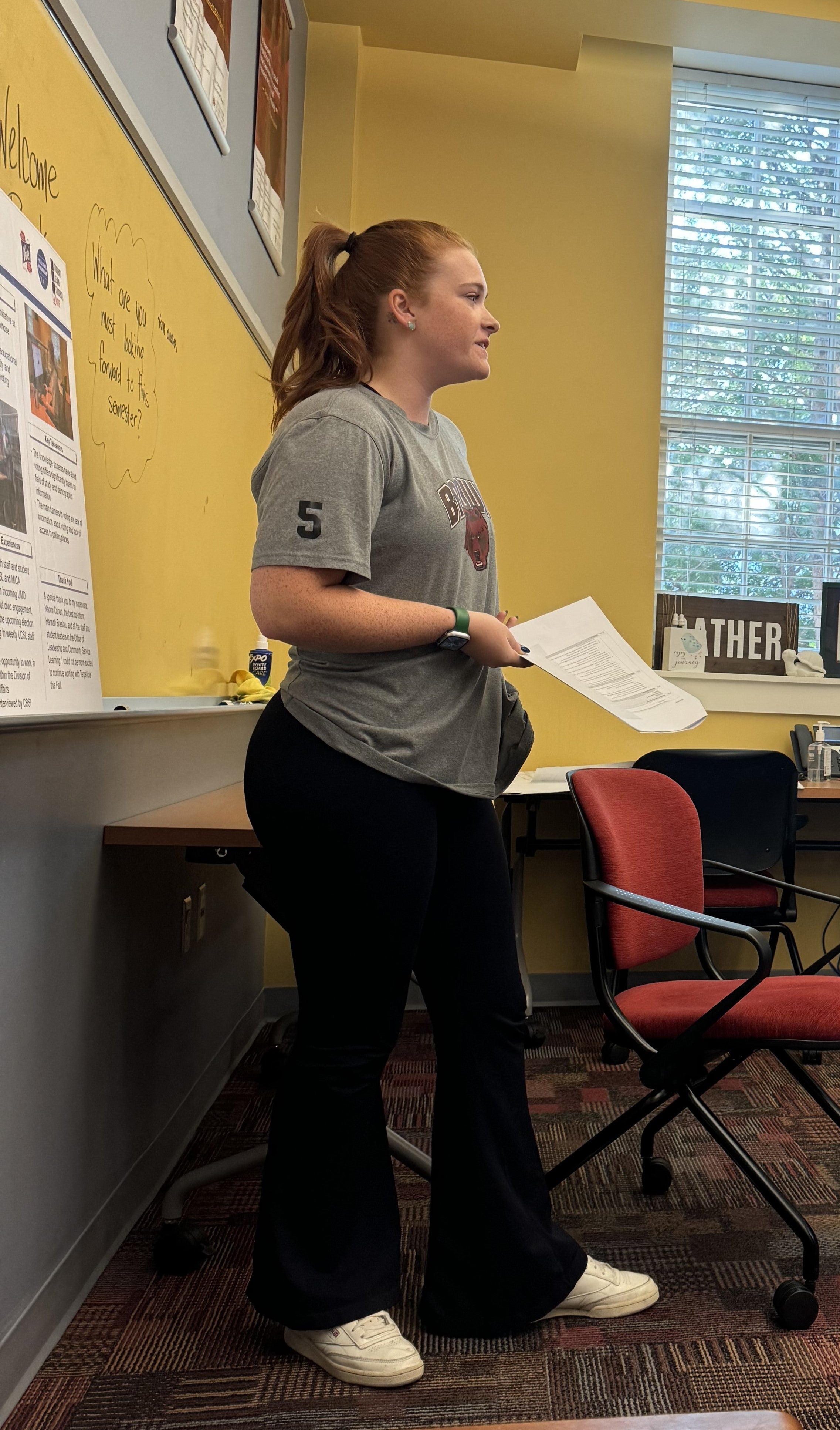 Photo of previous intern standing and faciltiating monday night meeting