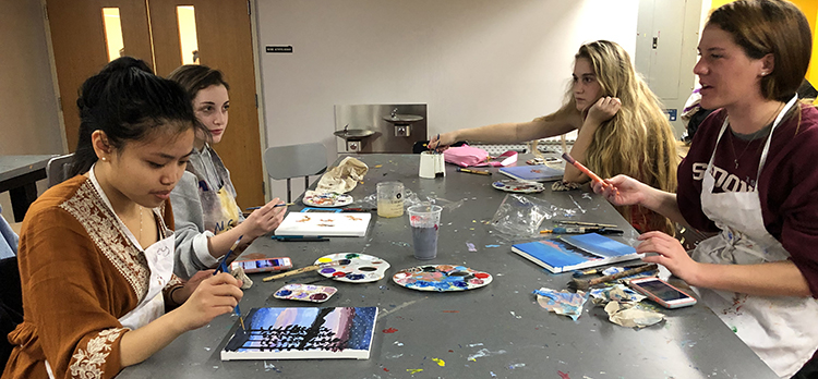 A group of 4 people painting