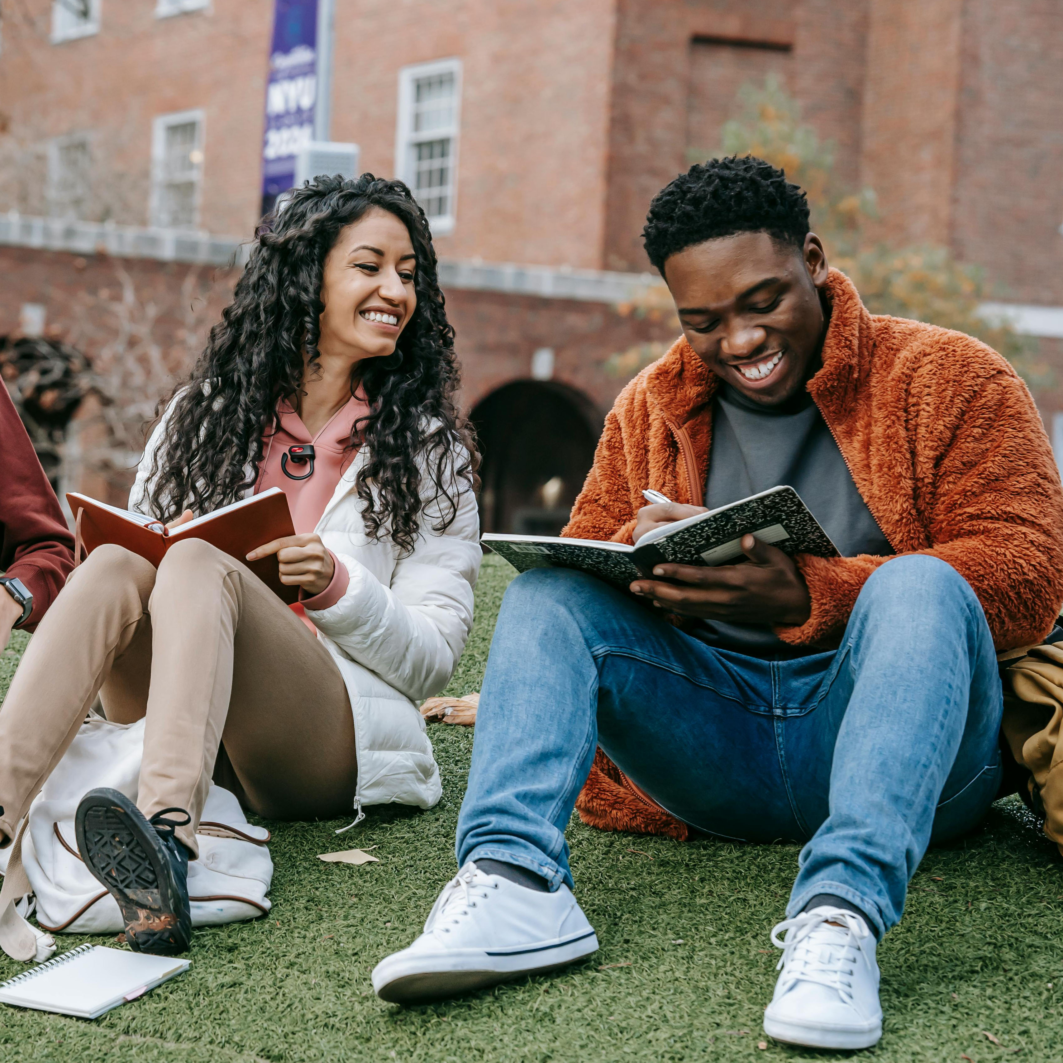 students sitting and writing on a notebook