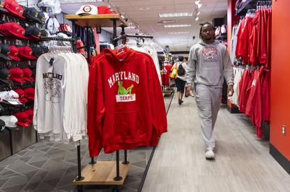 Student walking through the University Bookstore with Maryland gear.