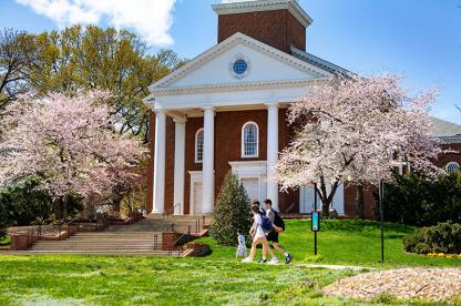 Cherry blossoms in bloom at Memorial Chapel with students walking.