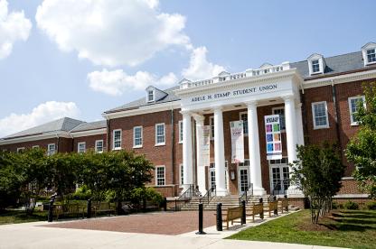 Front exterior column view of the Adele H. Stamp Student Union, with blue sky and clouds.