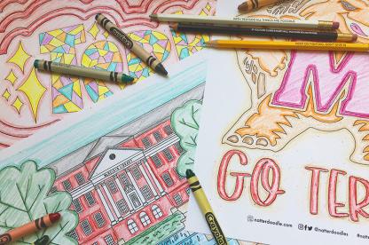 University of Maryland coloring pages on a table with crayons and pencils.