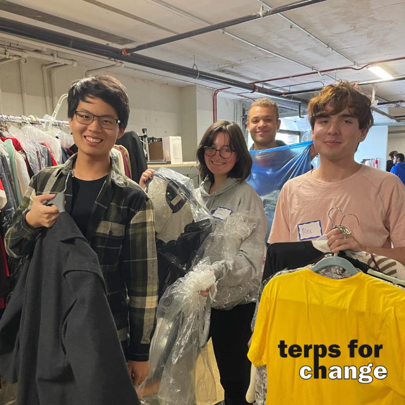 students sorting clothes smiling at camera