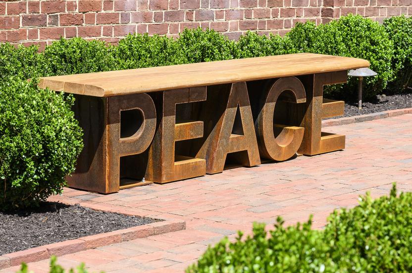 A wooden bench outside Memorial Chapel with letters spelling out the word "PEACE".