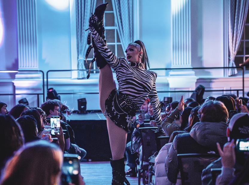 A drag queen performs for a large crowd in the STAMP Grand Ballroom 