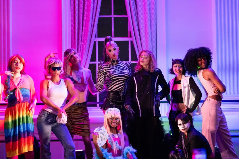 Student drag performers pose with Luxx Noir on a stage in the STAMP Grand Ballroom