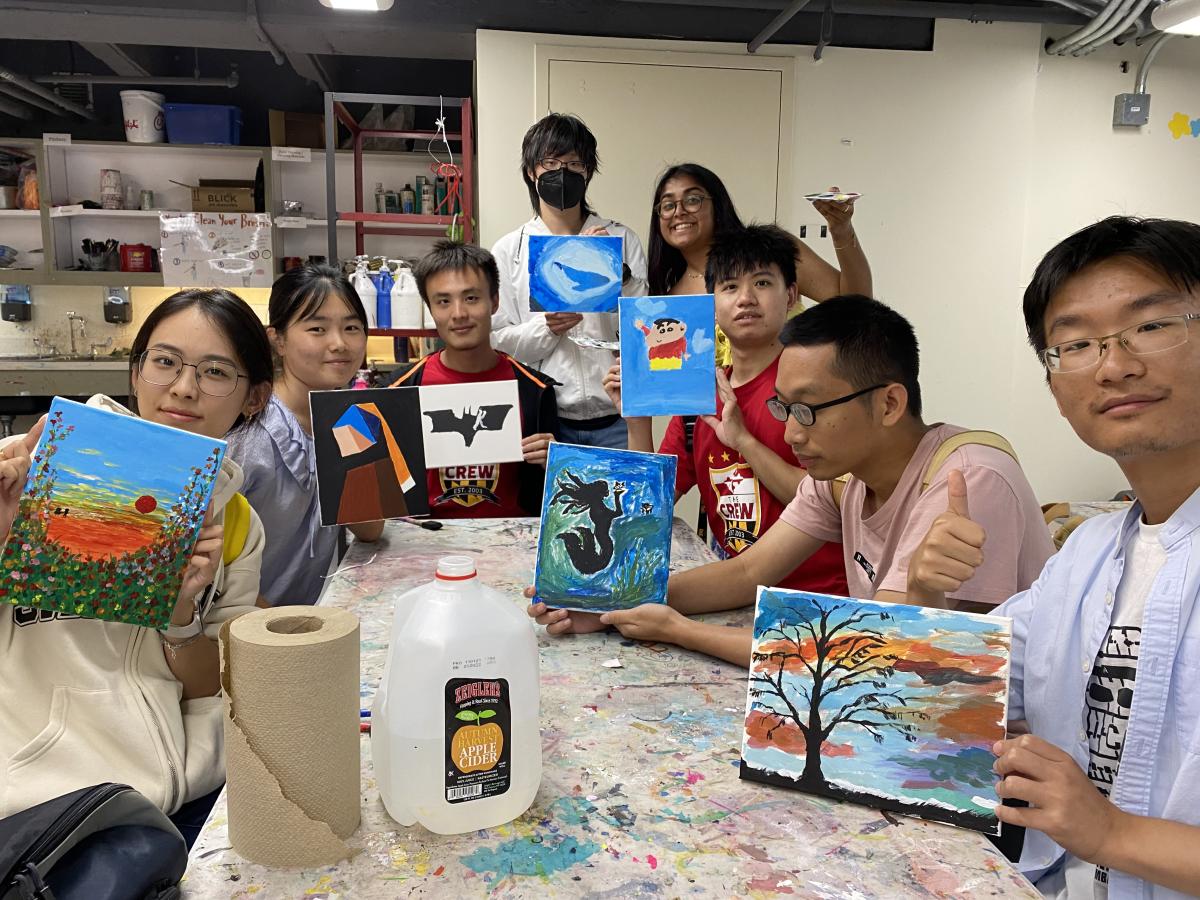 students showing their paintings
