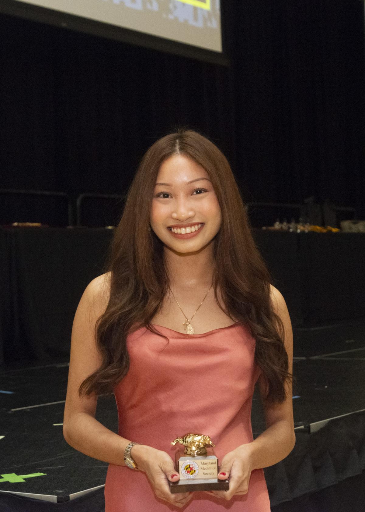 Image of a finalists holding her Maryland medallion Society award