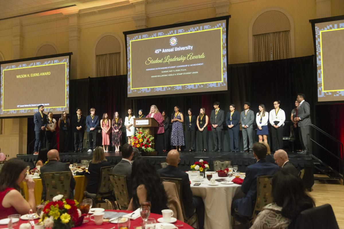 A photo of the 2026 Maryland Medallion Society on stage while Dr. Patty Perillo is spaking at the podium