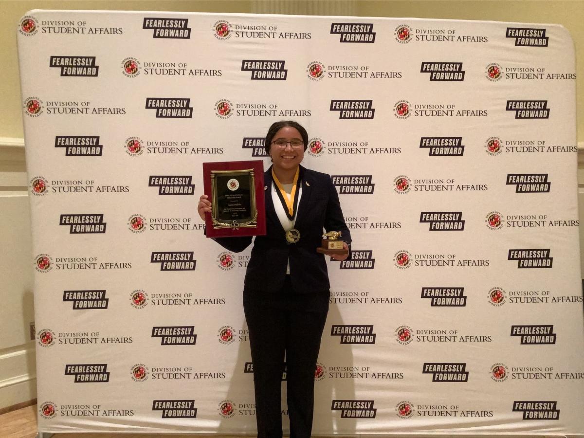 Photobooth photo of an award recipient holding her two awards