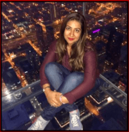 Picture of Fatimah sitting down at the top of the Willis Tower in Chicago