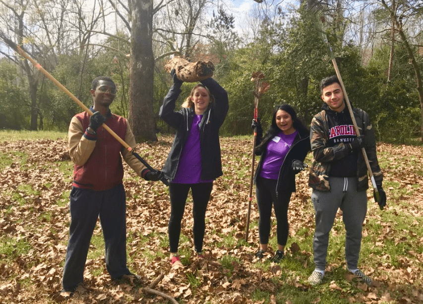4 AB volunteers pose while cleaning up a garden