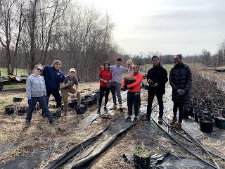 A group photo of 8 UMD Alternative Breaks Volunteers after completing service work with the Chesapeake Bay Foundation