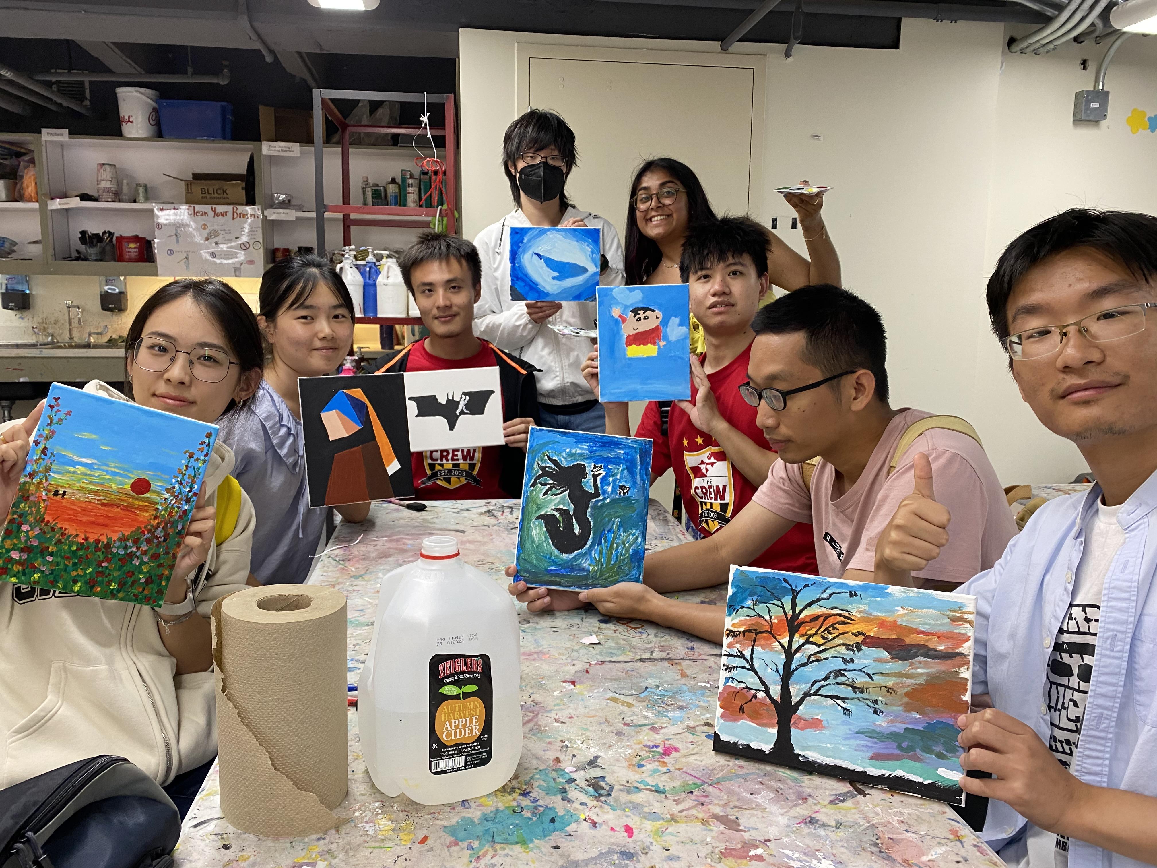 students showing their paintings