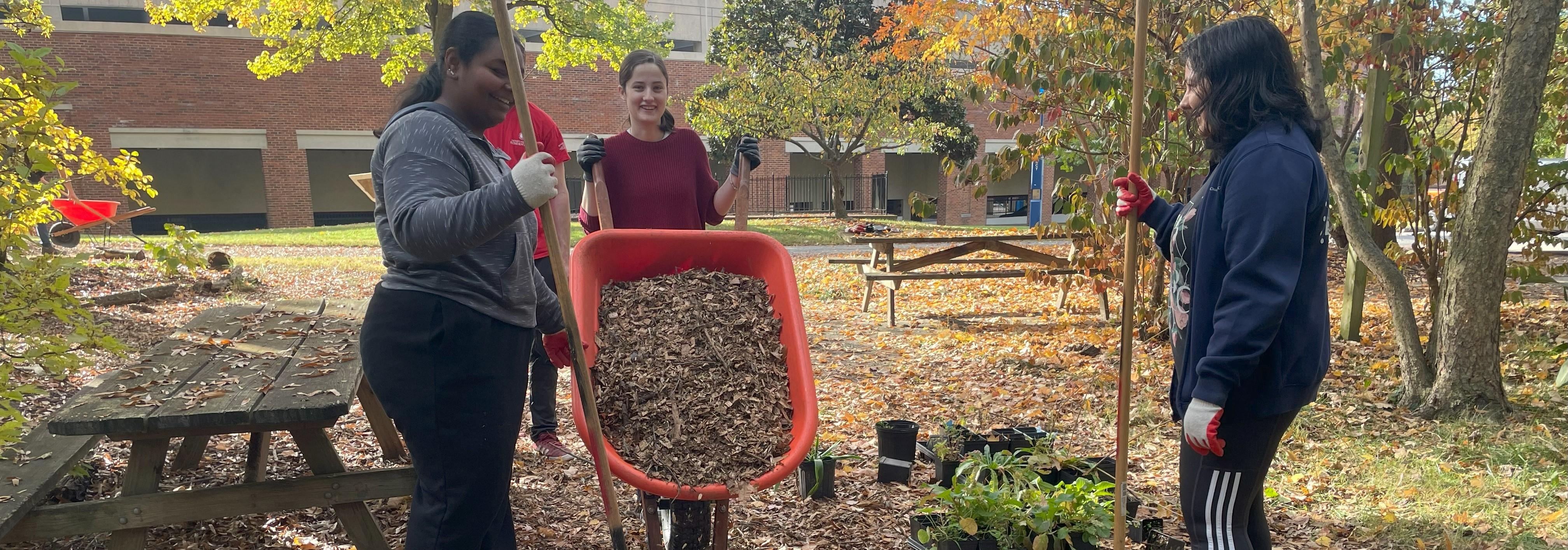 students working outside filling wheelbarrow