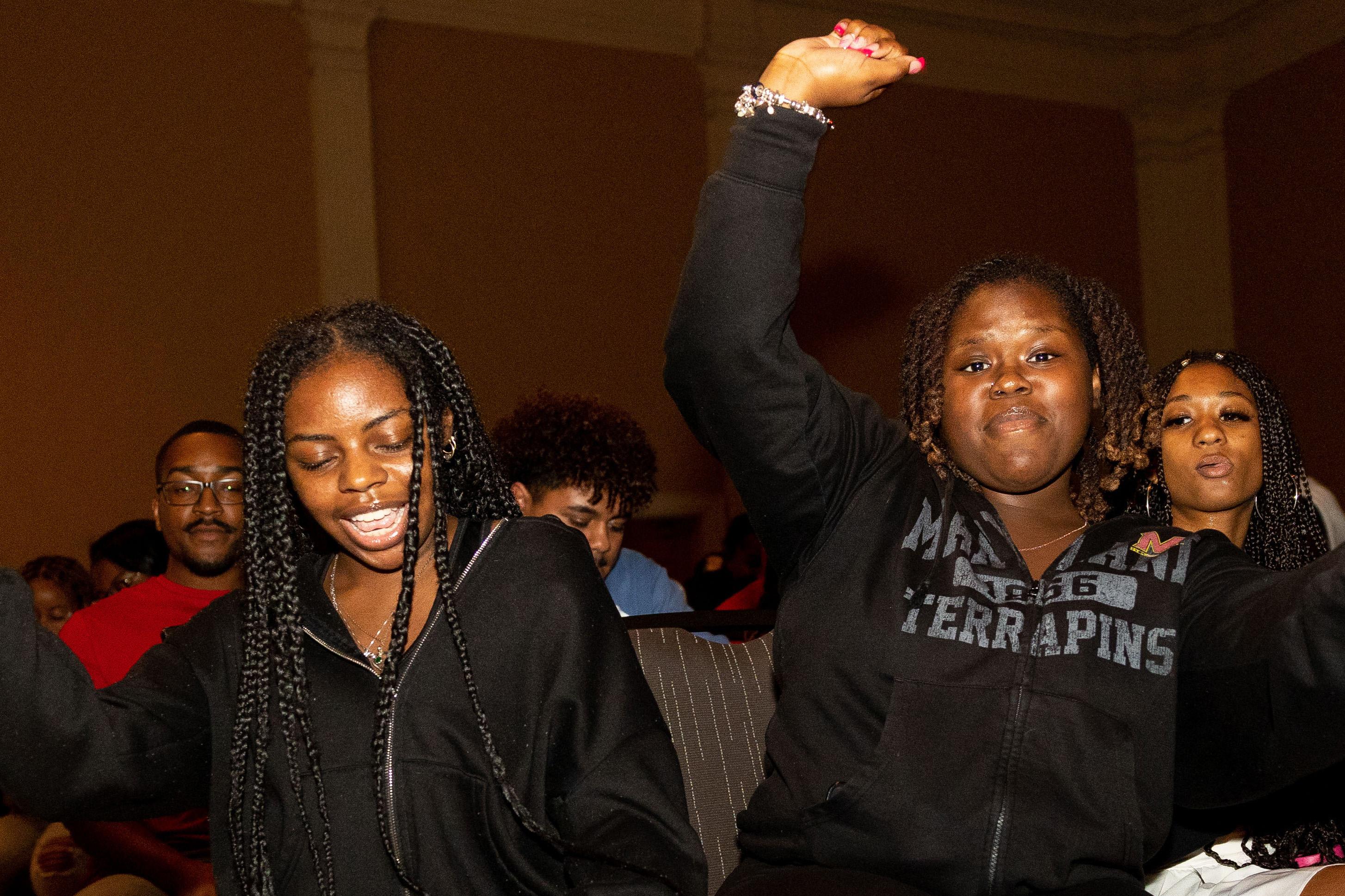 two students with one student with her right arm raised