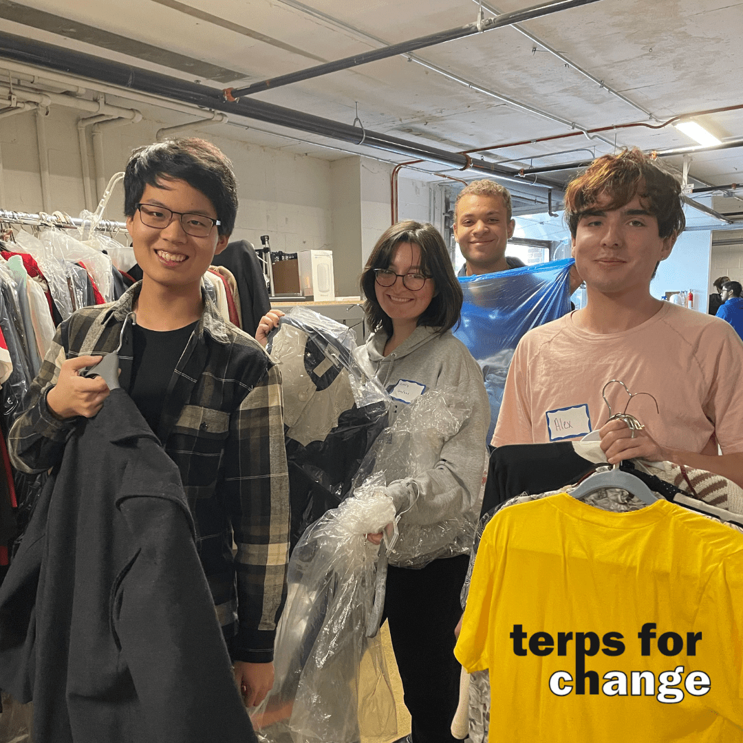 students sorting clothes smiling at camera