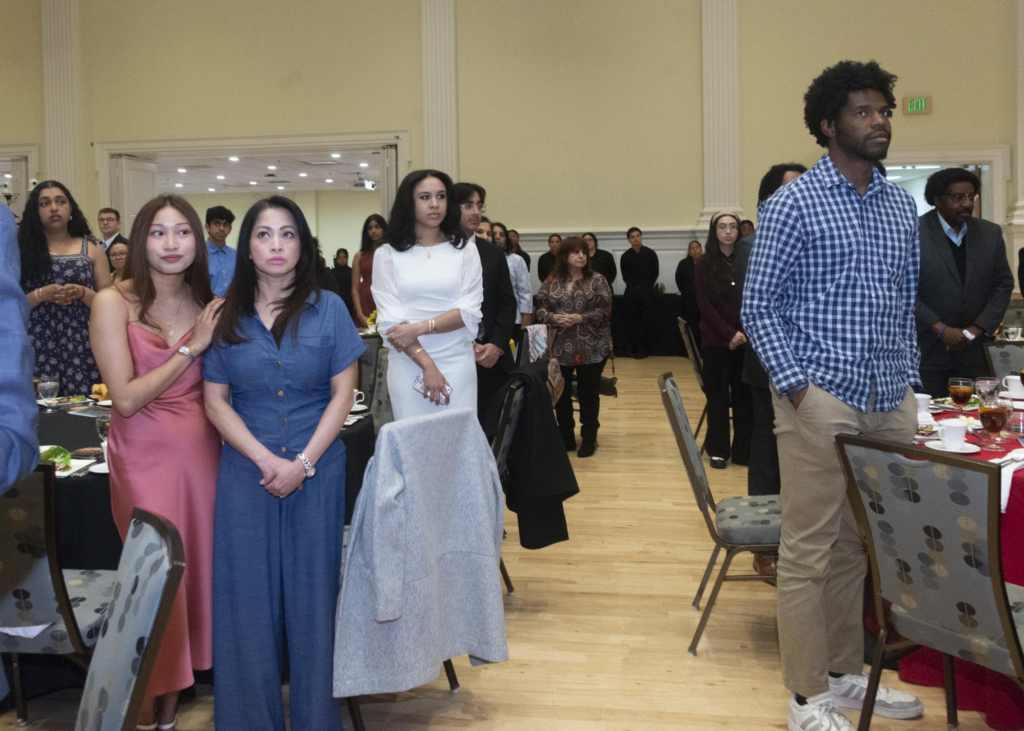 Photos of atendees standing during the alma mater