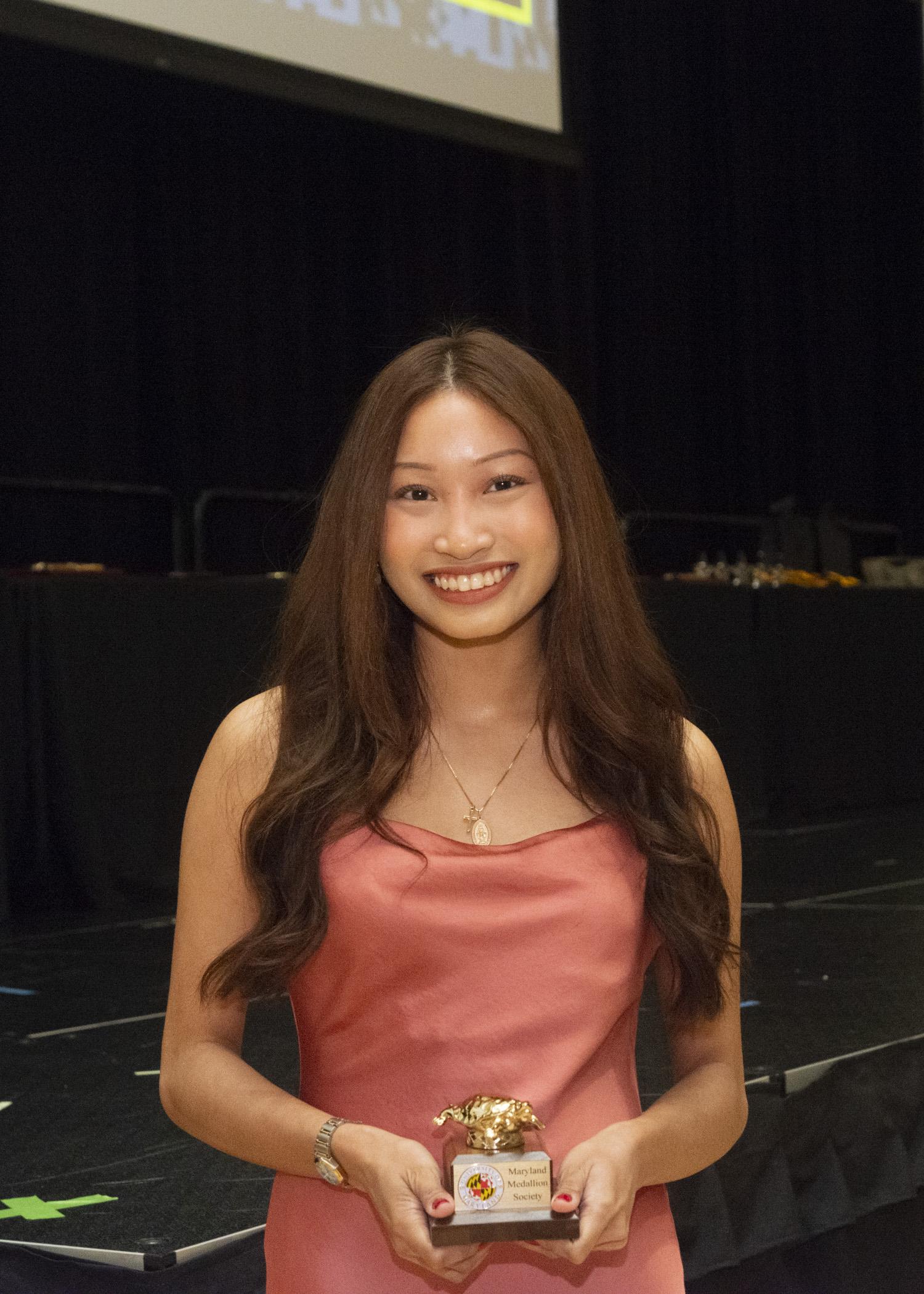 Image of a finalists holding her Maryland medallion Society award