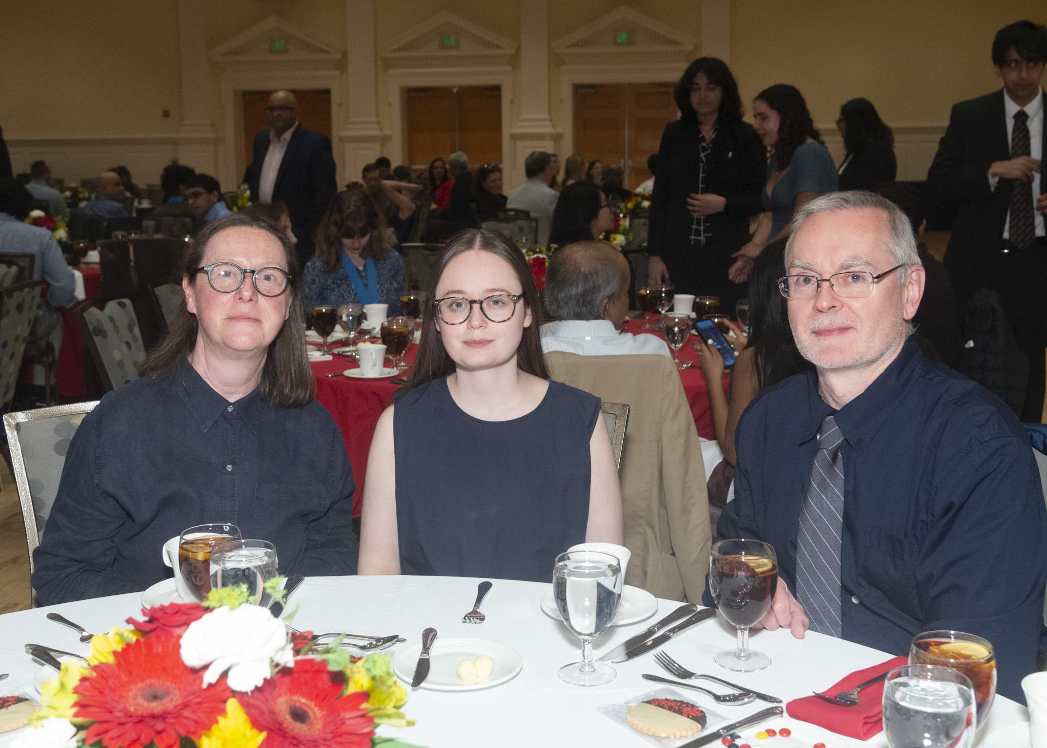 Photo of award recipient and her family sitting at the banquet table