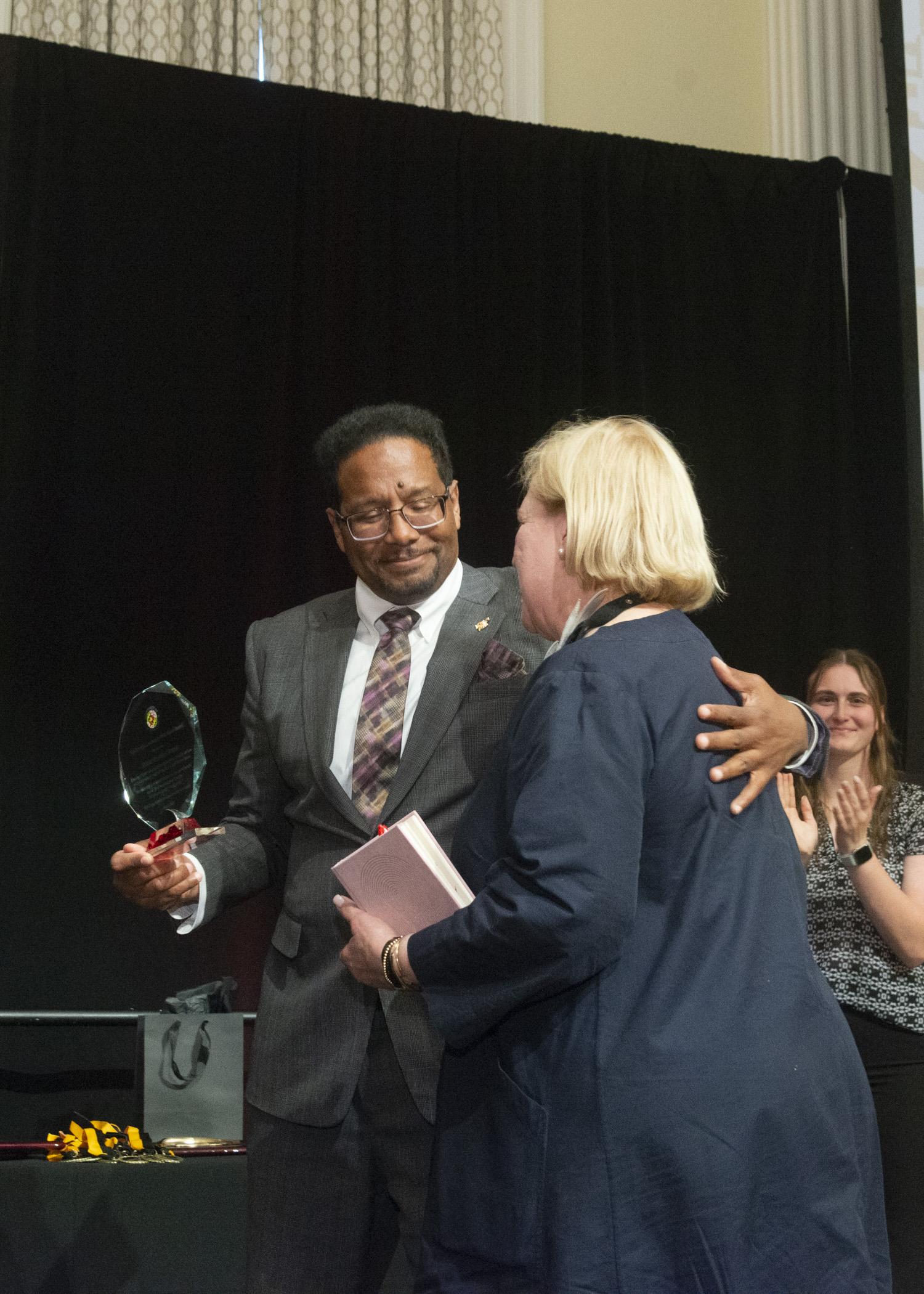 Photo of President Pines prsenting an award to Marsha Guenzler-Stevens, director of Stamp