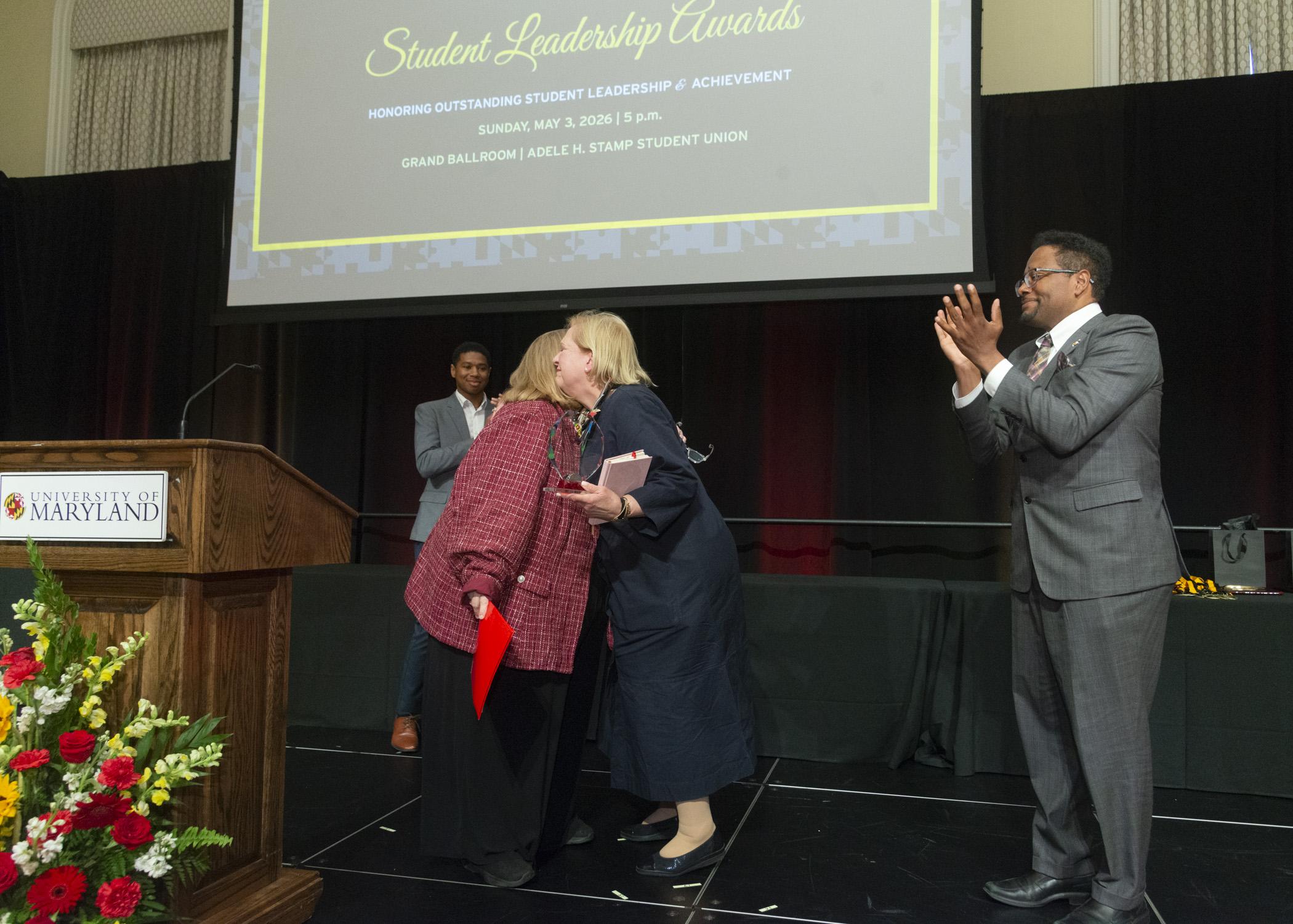 A photo of Marsha Guenzler-Stevens hugging VP Patty Perillo, hugging president Pines