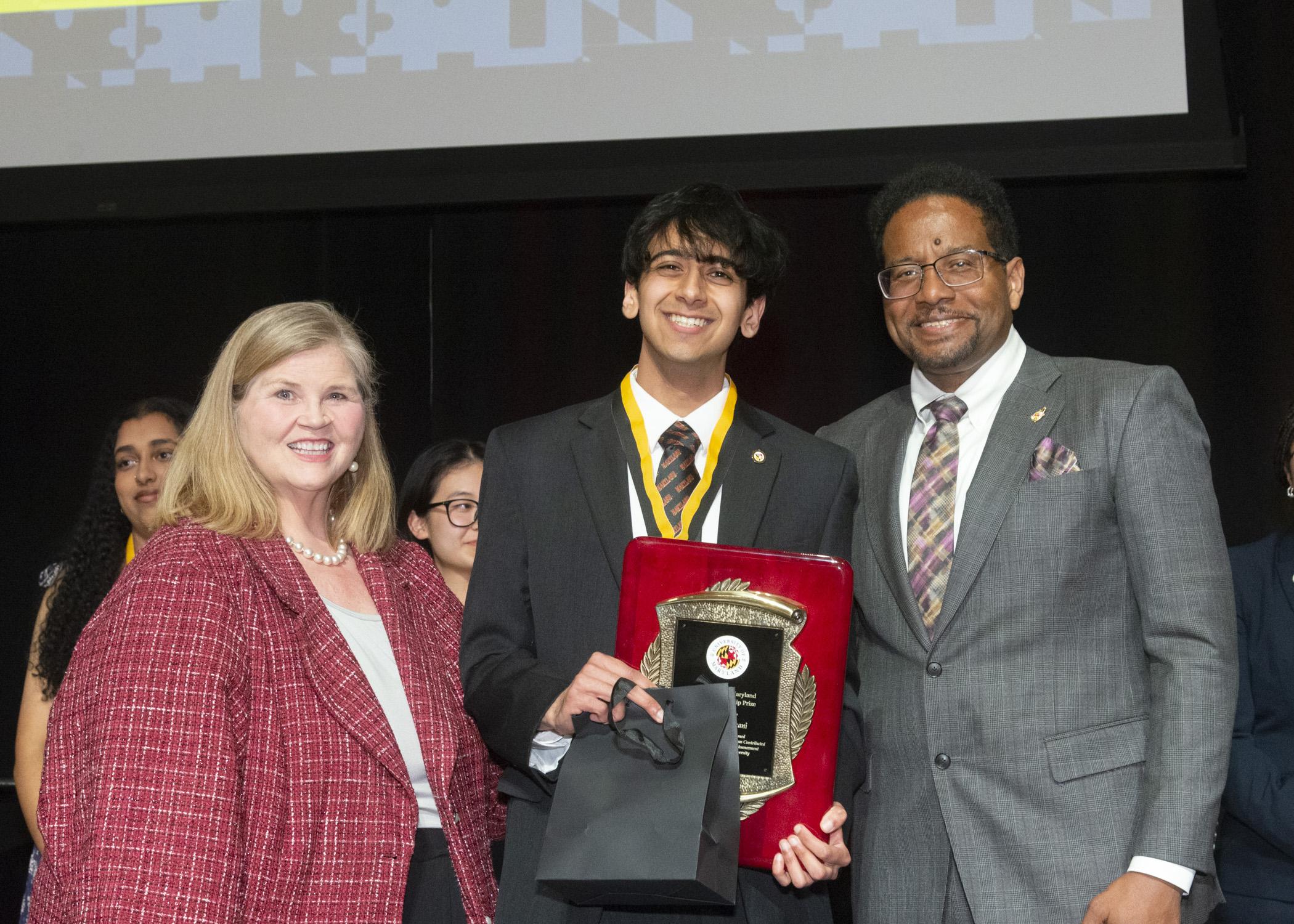A photo of Dr. Patty Perill, the Model citizenship prize recipient, Dhruvak Mirani, and President Pines