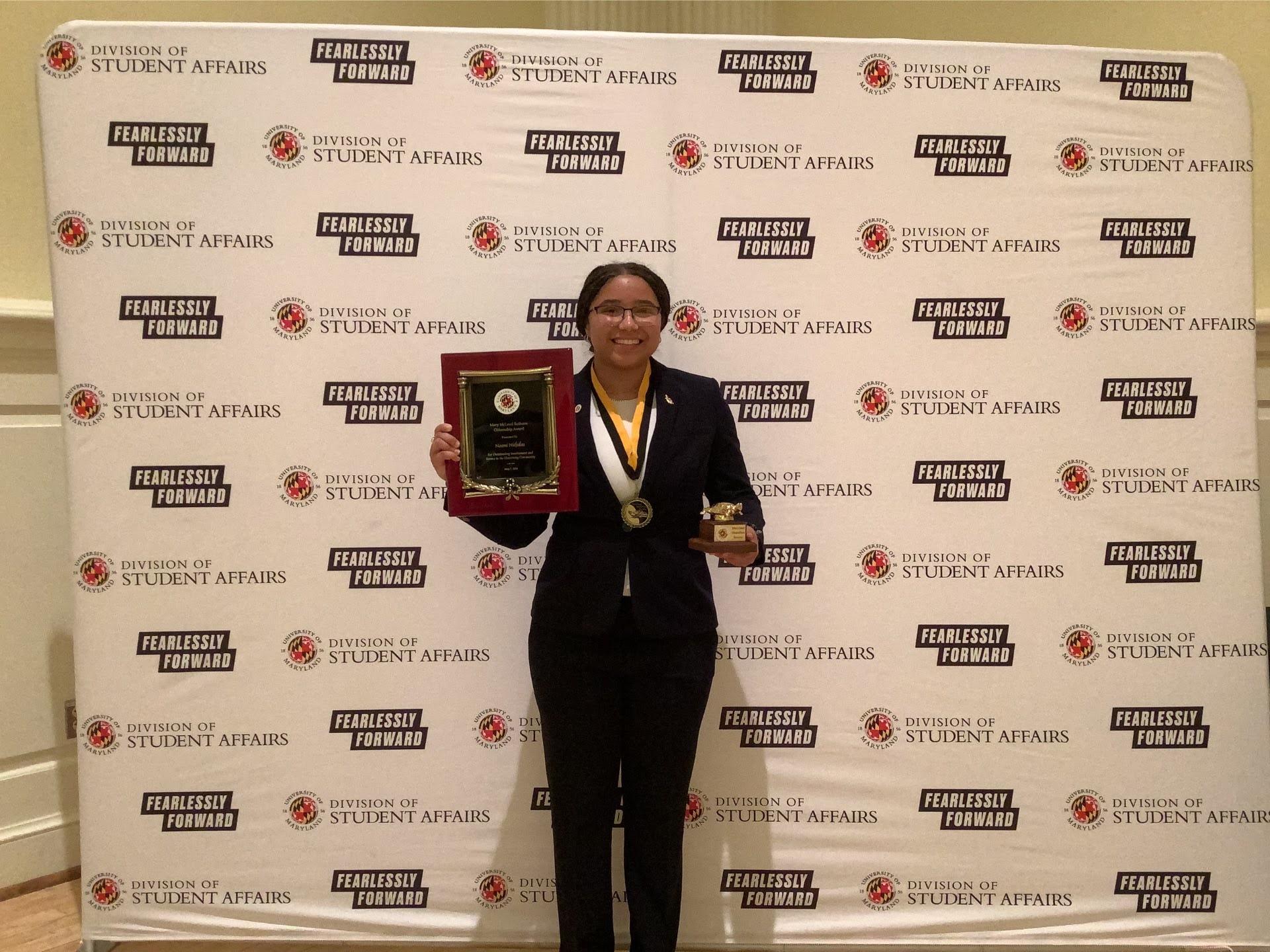 Photobooth photo of an award recipient holding her two awards