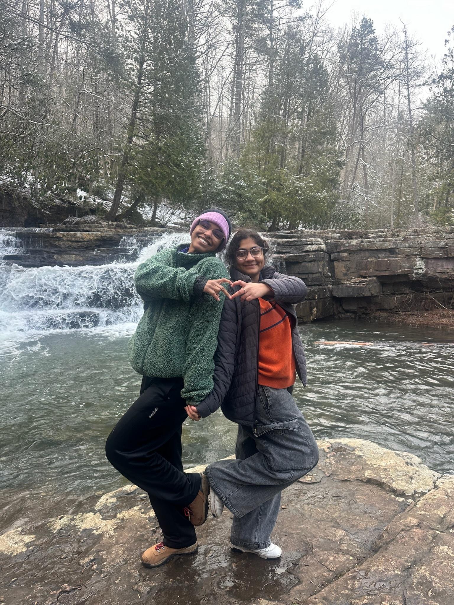 Two Experience Leaders pose together with a river in the background