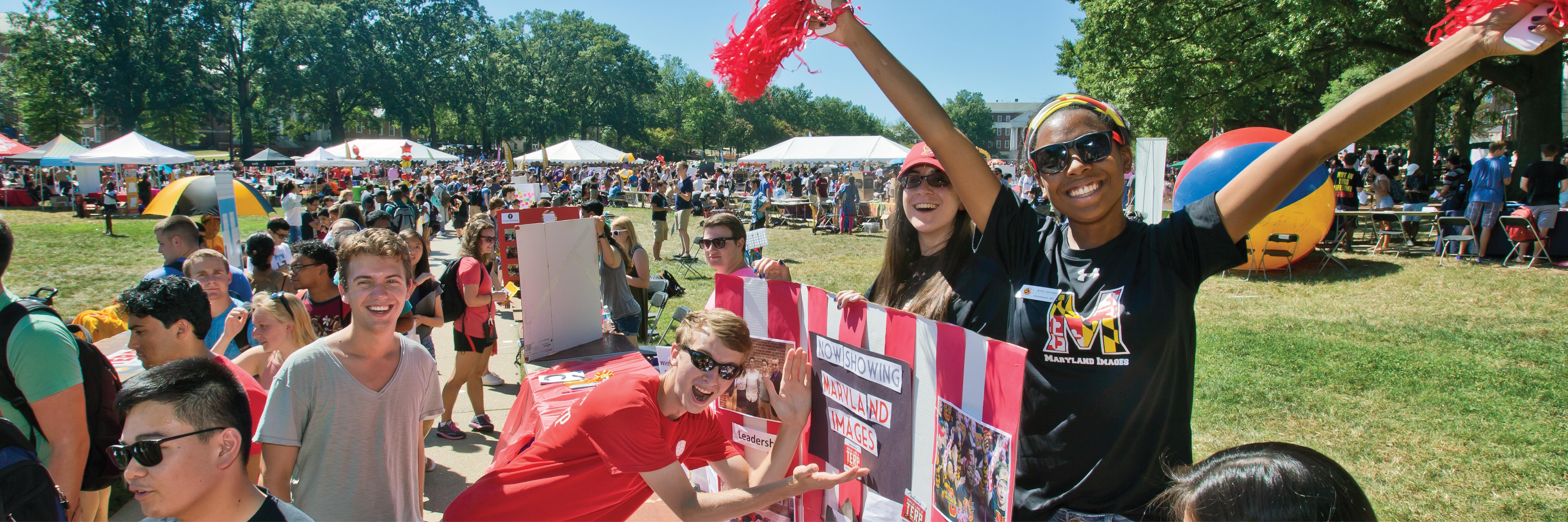 A group of students smiling on McKeldin Mall during the First Look Fair