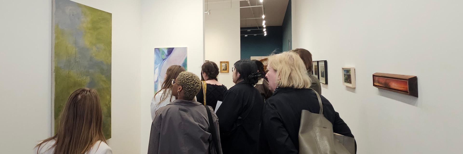An image of the 2024-2025 CAPP Committee viewing Xanthe Burdett's painting "The Woods Swallows Me"