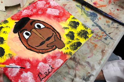 Canvas painting of Testudo's head on a red and yellow background.