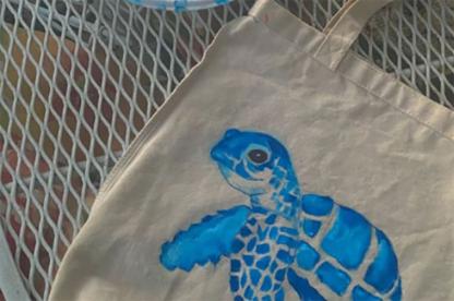 canvas tote bag with a painting of a blue turtle.