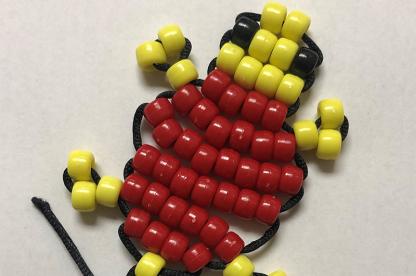 Turtle keychain made with yellow, black and red beads.