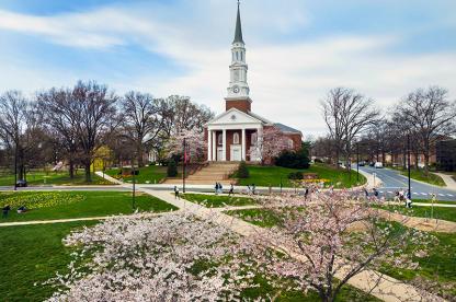 Aerial view of cherry blossoms in bloom outside Memorial Chapel with students walking on the sidewalks.